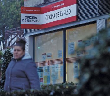 Una mujer frente a una Oficina de Empleo